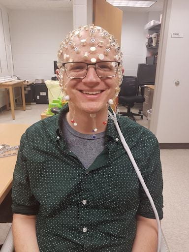 A photograph of the author with many electrodes on his scalp, all connected together in a plastic net.