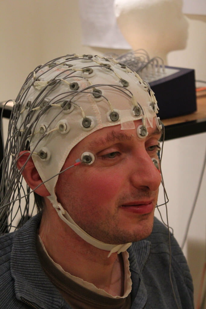Image of a man wearing a special white cap specific for EEG electrode placement.