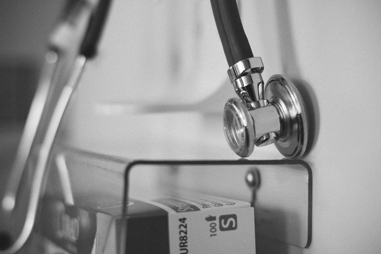 Black and white image of a stethoscope hanging on a wall.