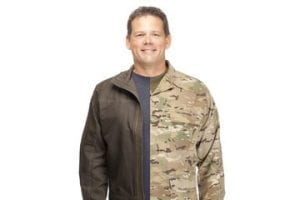 Man whose jacket is divided down the middle with civilian style work jacket on the left and military combat uniform jacket on the right side.